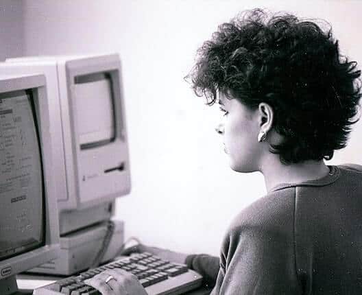 woman on legacy computer - 7 Risks of Using Legacy Software