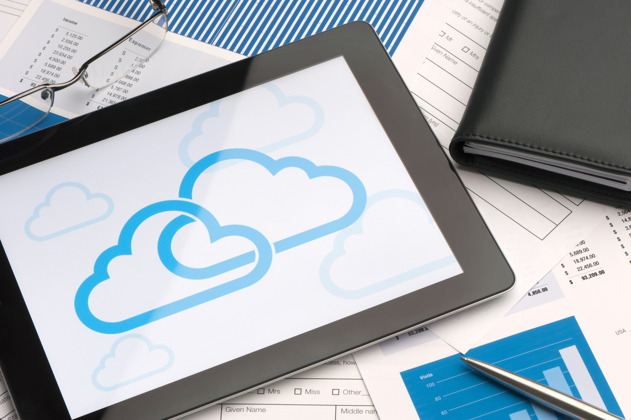 Cloud icon on a digital tablet woman using Cloud Services at work to complete business tasks on laptop with female co-worker